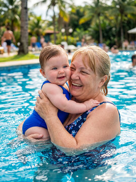 Grandmother holds baby in swimming pool