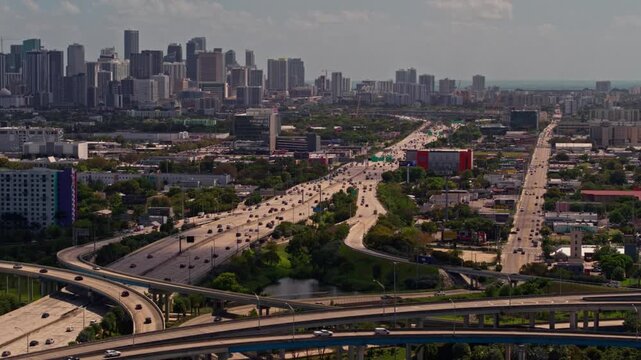 Miami sunset downtown cityscape aerial drone view over big elevated intersection static camera urban highway infrastructure florida in 4K Ultra HD footage.
