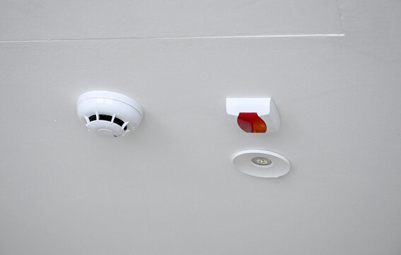 Fire detection system with smoke detector and heat sensor. Modern fire alarm system on ceiling in home. 