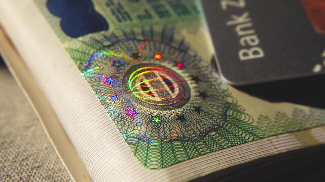 A close-up of the illuminated holographic emblem of the EU Schengen visa. The iridescent multicolor security hologram of the Schengen visa of the European Union countries. 4k slow motion video 60 fps.