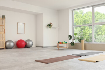Obraz premium Interior of gym with sports equipment, table and window