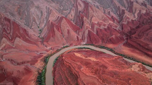Aerial view of the Colorado River winding through dramatic red rock formations and steep canyon walls in Moab, Utah, United States.