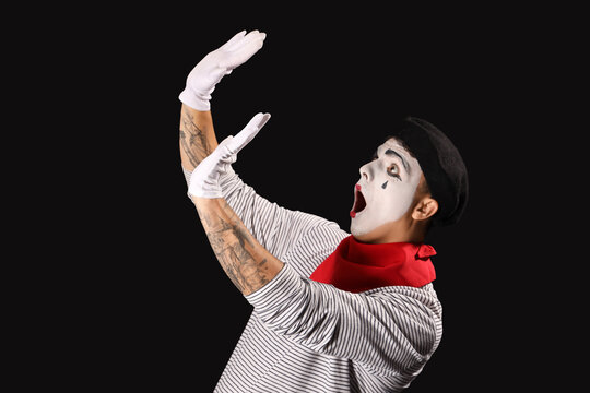 Shocked male pantomimist on black background