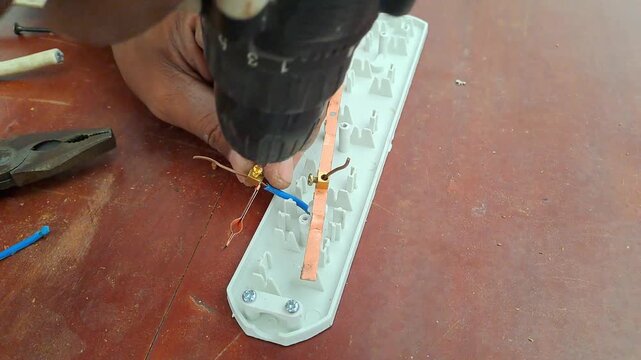 Technician drilling wooden library table with power drill for electrical outlet installation. Worker assembling socket wiring. Construction stock video 4K for DIY, renovation, carpentry, maintenance, 