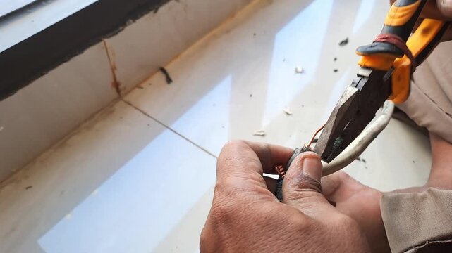 Technician connecting electrical wires for outlet using pliers and hot glue gun. Wiring installation and insulation process. Electrician stock video 4K for DIY, renovation, safety, construction, maint
