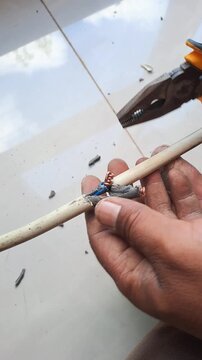 Technician connecting electrical wires for outlet using pliers and hot glue gun. Wiring installation and insulation process. Electrician stock video 4K for DIY, renovation, safety, construction, maint