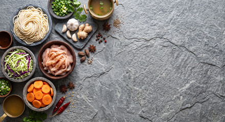 Fototapeta premium Overhead flat lay of Himalayan Thukpa noodle ingredients on slate stone surface