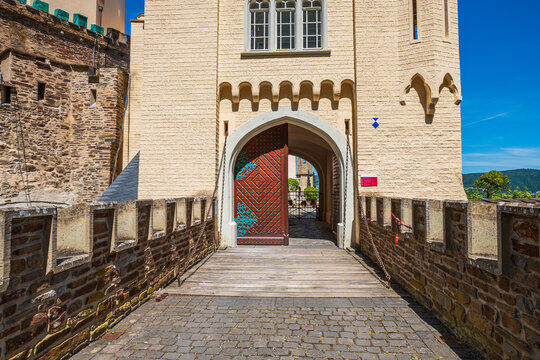 Medieval castle entrance drawbridge gate, ancient stone fortress fortification wall with open wooden door, historic European architecture on a sunny day