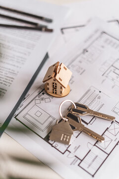 House model, keys and floor plans create visual representation of selecting ideal residence. Concept of architectural planning, smart investment and personalized housing decisions.