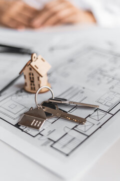 Miniature house and keys displayed above contract papers symbolize mortgage approval and residential financing. Professional consultation helps clients secure ideal property solutions.