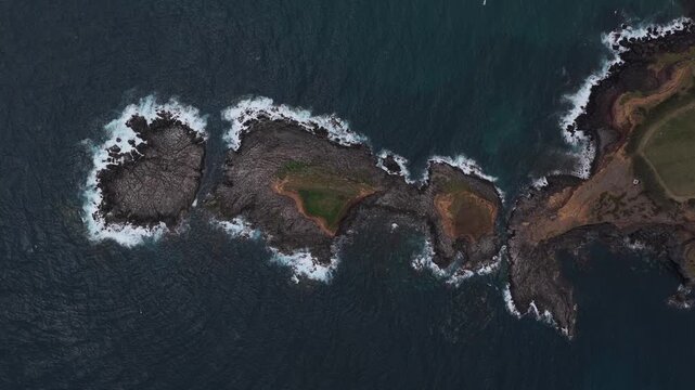 Aerial view of the rugged coastline and rocky islets near Forte da Greta in Vila de Sao Sebastiao, Azores, Portugal.