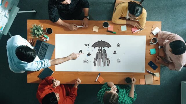 Collaborative Team Meeting with Brainstorming Ideas Over a Table Surrounded by Laptops, Notes, and Creative Illustrations Sigmoid