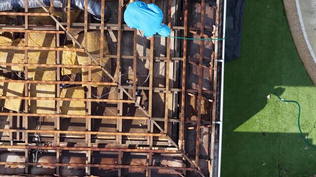 Aerial View of Worker in Hazmat Suit Removing Asbestos from Roof