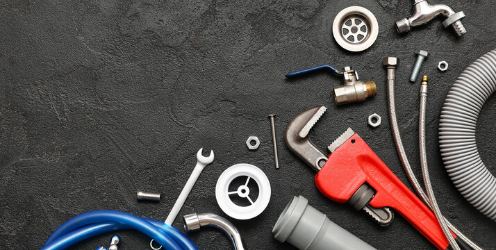 Plumbing tools and parts on black background