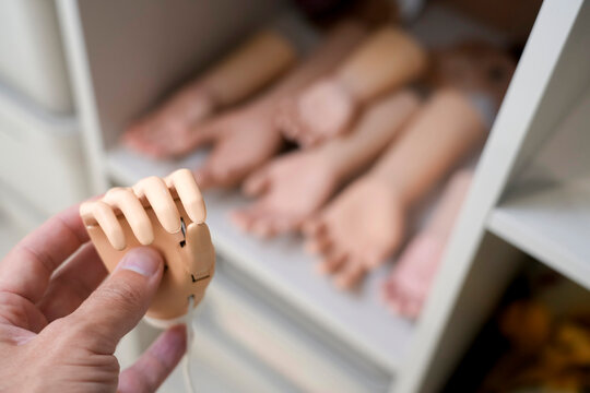 Hand holds a kids child plastic prosthetic arm.