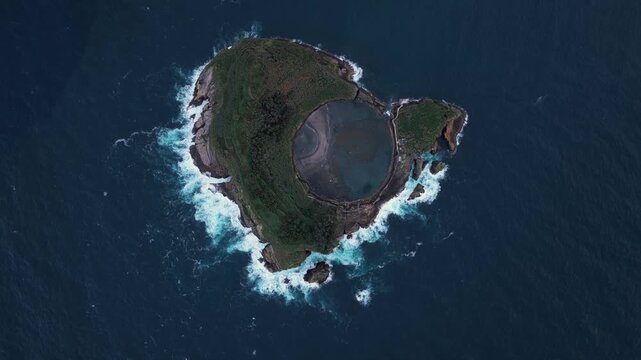 Aerial view of the volcanic crater islet Ilheu de Vila Franca do Campo surrounded by the deep blue Atlantic Ocean in Sao Pedro, Acores, Portugal.