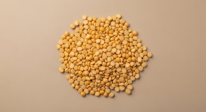 Top view of a pile of yellow split peas on a beige background