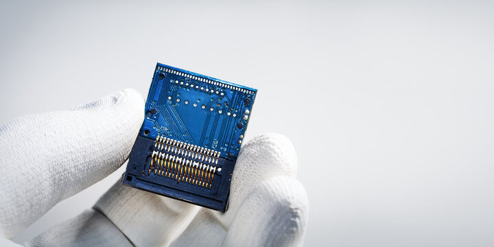 Close-up of gloved hand holding a microchip. Banner with place for text.