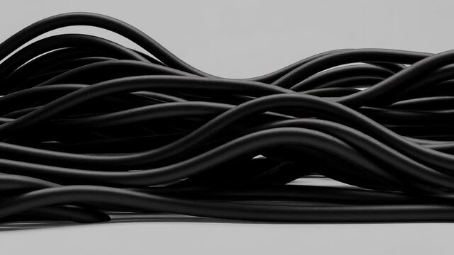 Close up of tangled black electrical cables on a neutral background in abstract technology concept