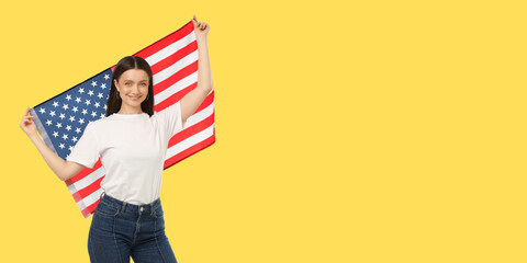 Fototapeta premium Woman waves American flag joyfully. Celebration and travel concept in bright yellow space