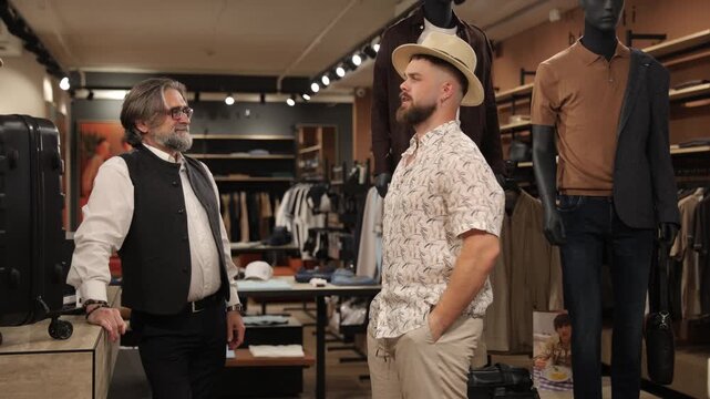 Young man trying on panama hat in clothing store