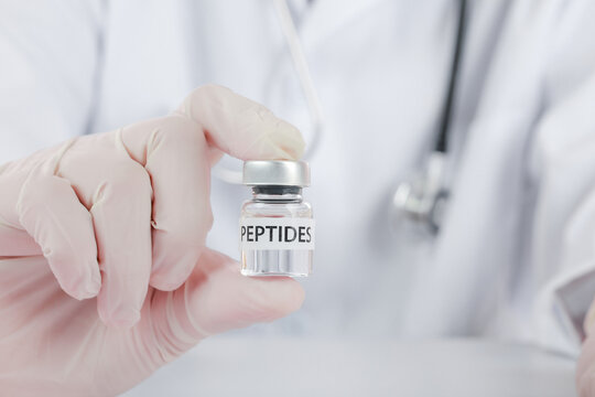 Confident doctor wearing glove holding peptide vial inside wellness clinic showcasing innovative medical treatment therapy