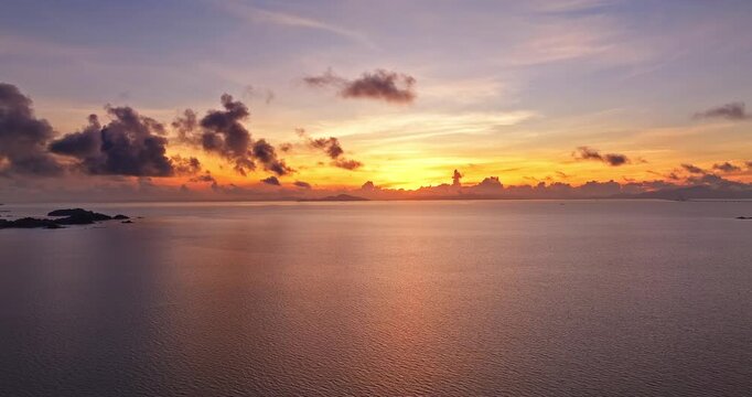 Golden hour sunrise over the calm ocean with dramatic sky and clouds in Zhuhai, Guangdong, China.