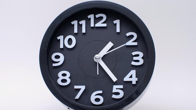 Tme lapse video of a clock time passing over a day to night on white background.