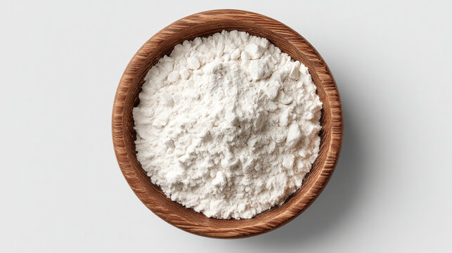 Pile of white baking flour in a small wooden bowl top view with ingredient culinary isolated