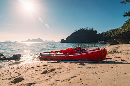 Red kayaks resting on sandy beach on a sunny day
