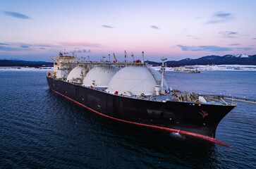 Aerial of Liquified Natural Gas LNG carrier moored to a small gas terminal. Fuel crisis. Sanctions © Evgenii Bakhchev