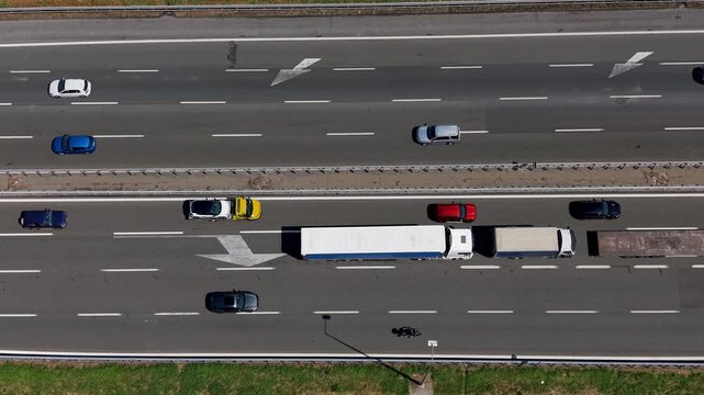 Aerial view of a congested highway in Italy. Traffic is at a standstill as trucks and cars fill the roadway.