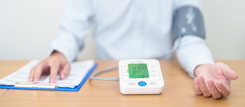 Man checking Blood pressure by Blood pressure monitor with Cuff. Systolic, SYS, Diastolic, DIA, Pulse, Hypertension, Hypotension, Heart rate, Cardiovascular Disease and May World hypertension day