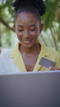 Young african american woman shopping online using laptop