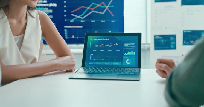 Closeup group Asian businesspeople work together discuss plan idea with investment profit sale statistics in business meeting in office. Financial generation z team brainstorm on e-Commerce project.