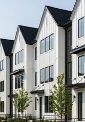 Obraz premium Modern White Townhouses with Black Trim and Gabled Roofs in a New Residential Development