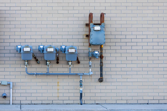 Gas meters measuring utility energy consumption on brick wall