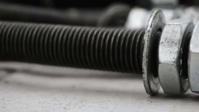 Detailed macro view of a heavy-duty anchor bolt with nut and washer used for steel construction, industrial installation and structural engineering applications.