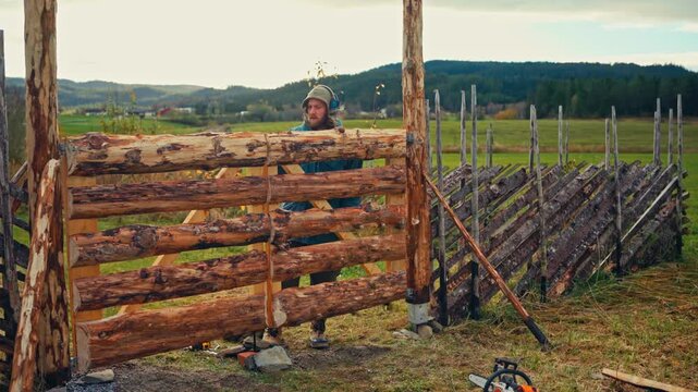 Rustic Wooden Fence Being Constructed From Natural Logs In Countryside. Static Shot