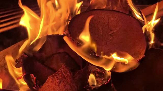 Coconut shells burning in a bright fire close up