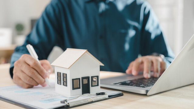 Signing real estate contract property mortgage finance approved home buying document including house investment insurance process for homeowner and tenant using laptop at office work desk