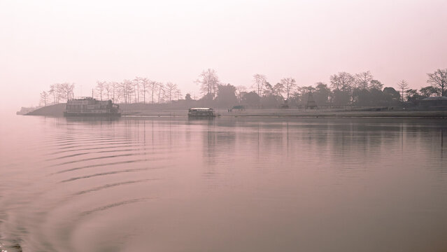 Misty morning on the river. ishing boat on the river. Traditional Bamboo Lift Nets and Fishing Boats at Sunrise on the Brahmaputra River, Majuli Island, Assam, India.