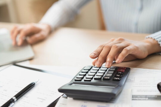 person using calculator calculating tax refund on the table