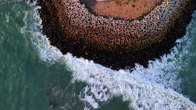Scenic Aerial View of Ocean Waves Hitting Concrete Tetrapods Along the Coastal Shoreline with Powerful Sea Movement, Coastal Protection Structure, Blue Ocean Water, Marine Landscape and Dramatic Seasi