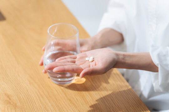 薬を飲む女性。医薬品、サプリメント、常備薬、ジェネリック