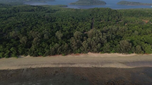 Cinematic aerial footage capturing tropical islands rising from the Andaman Sea near Koh Jum in Krabi Thailand. Lush green forest and peaceful coastal scenery create a premium travel destination view