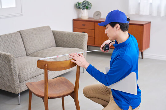 椅子のサイズを測る作業員