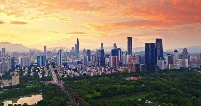 Aerial view of financial district skyline and dense urban cityscape at golden sunrise in Shenzhen, China