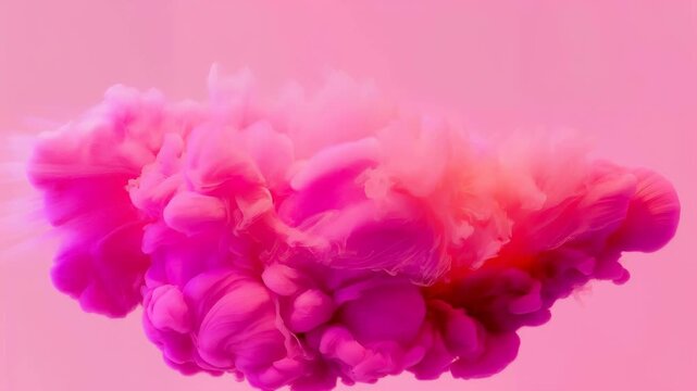 Colorful pink cloud of swirling ink gradually expands and transforms in a vibrant pink background, showcasing a dynamic flow of color and texture