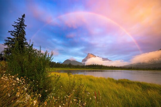 Colorful sky with clouds over a river and green landscape